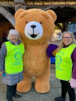 Rotarians being supported by a huge teddy bear, who attracted lots of attention from passers by
